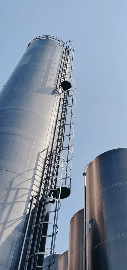 A large cylindrical silo with ladder Description automatically generated with medium confidence