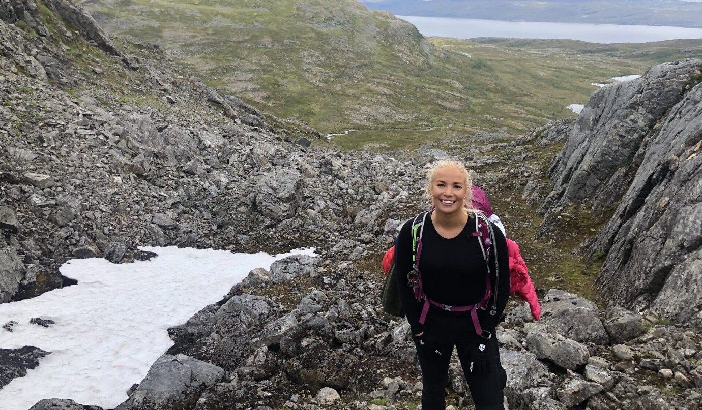 A person standing on a rocky mountain Description automatically generated